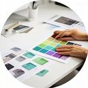 Grafikdesigner am Arbeitstisch mit Verpackungsmustern und Farbkarten